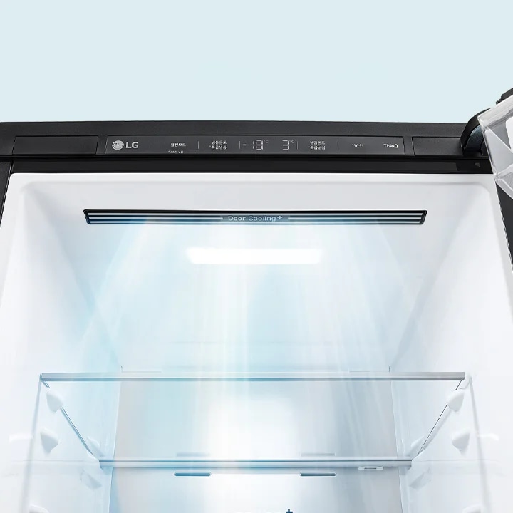 LG 로고가 있는 냉장고의 내부 모습입니다. 냉장고 문 안쪽에 Door Cooling+라는 텍스트가 있으며, 냉장고 내부에 밝은 조명이 켜져 있습니다. 상단 패널에는 온도와 관련된 정보가 표시되어 있습니다.