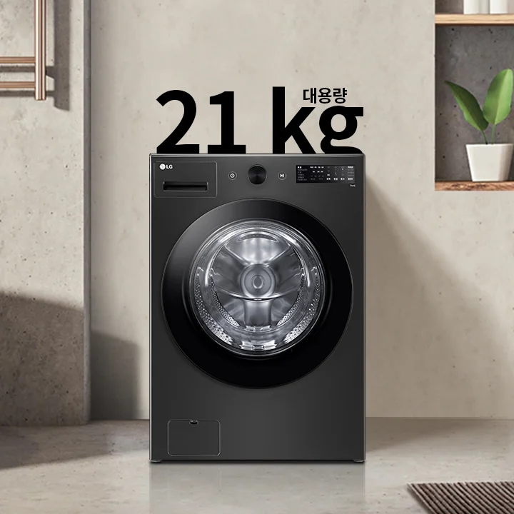 세탁기가 욕실에 놓여 있으며, 세탁기 위에는 21kg 대용량이라는 텍스트가 있습니다. 세탁기 옆에는 욕조와 수건이 걸려 있고, 벽 선반에는 식물과 용기가 놓여 있습니다.