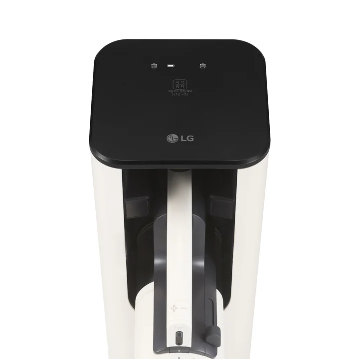 검은색 상단 패널에 LG 로고가 있으며, 두 개의 아이콘이 있습니다. 왼쪽에는 쓰레기통 모양의 아이콘이 있고, 오른쪽에는 동일한 모양의 아이콘이 있습니다. 그 사이에 작은 불빛이 하나 보입니다. 중앙에는 사용 중이라는 문구와 함께 사용 중에는 열지 마세요라는 경고 문구가 적혀 있습니다. 청소기의 본체는 흰색과 회색으로 구성되어 있으며, 손잡이 부분에는 +와 - 기호가 있는 버튼이 있습니다.