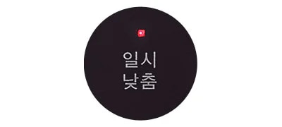 검은색 원 안에 일시 낮춤이라는 텍스트가 있으며, 그 위에 작은 빨간 불빛이 켜져 있습니다.