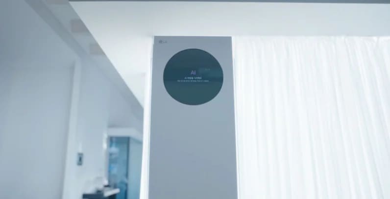 AI바람 기능을 설명하는 썸네일 이미지로 밝은 실내 공간 중앙에 스탠드형 에어컨이 설치되어 있으며, 상단의 원형 블랙 디지털 디스플레이가 보입니다. 에어컨의 양쪽 토출구에서 푸른색 선 형태의 기류 그래픽이 실내 전반으로 퍼져 있습니다. LG WHISEN AI AI바람 이라는 문구가 표시되어 있습니다. 오른쪽에는 커튼과 벽면 구조가 보이는 주거 공간이 이어집니다. 이 이미지는 AI 제어를 통해 실내로 바람을 고르게 분산시키는 에어컨의 바람 제어 기능을 설명합니다.