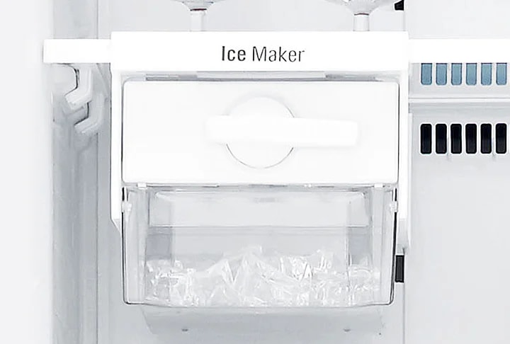Ice Maker라는 텍스트가 적힌 얼음 제조기가 보입니다. 투명한 용기 안에 얼음이 담겨 있으며, 기기는 깔끔한 흰색으로 디자인되어 있습니다. 주변은 주방 기기의 일부분으로 보이는 배경입니다.